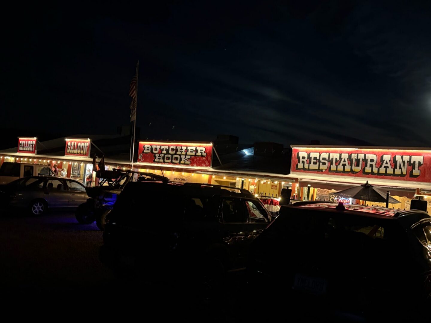 Illuminated roadside restaurant with parked cars