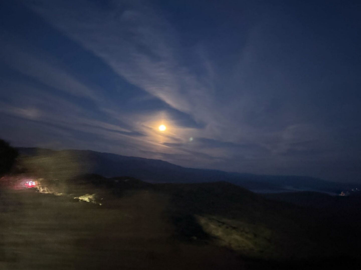 Moonlit sky above dark mountain landscape