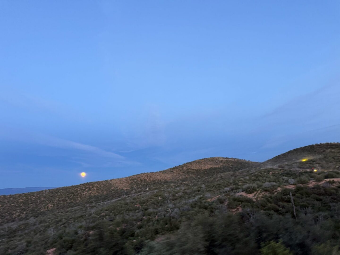 Moonrise over desert hills at dusk