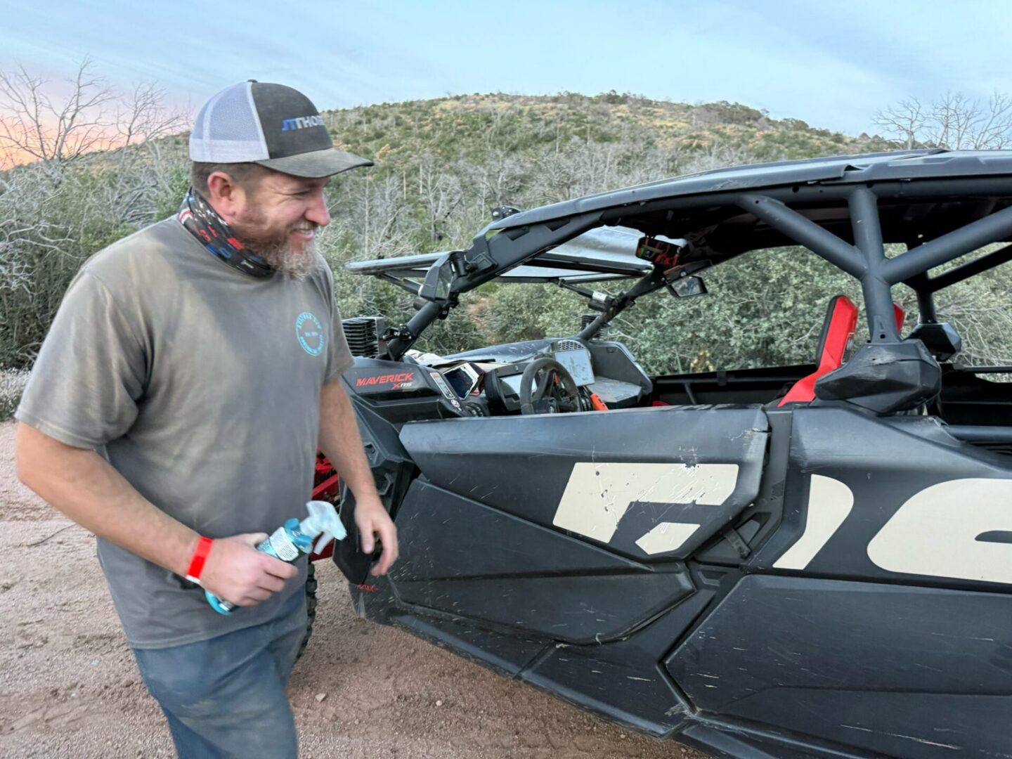 Smiling man standing by black off-road UTV