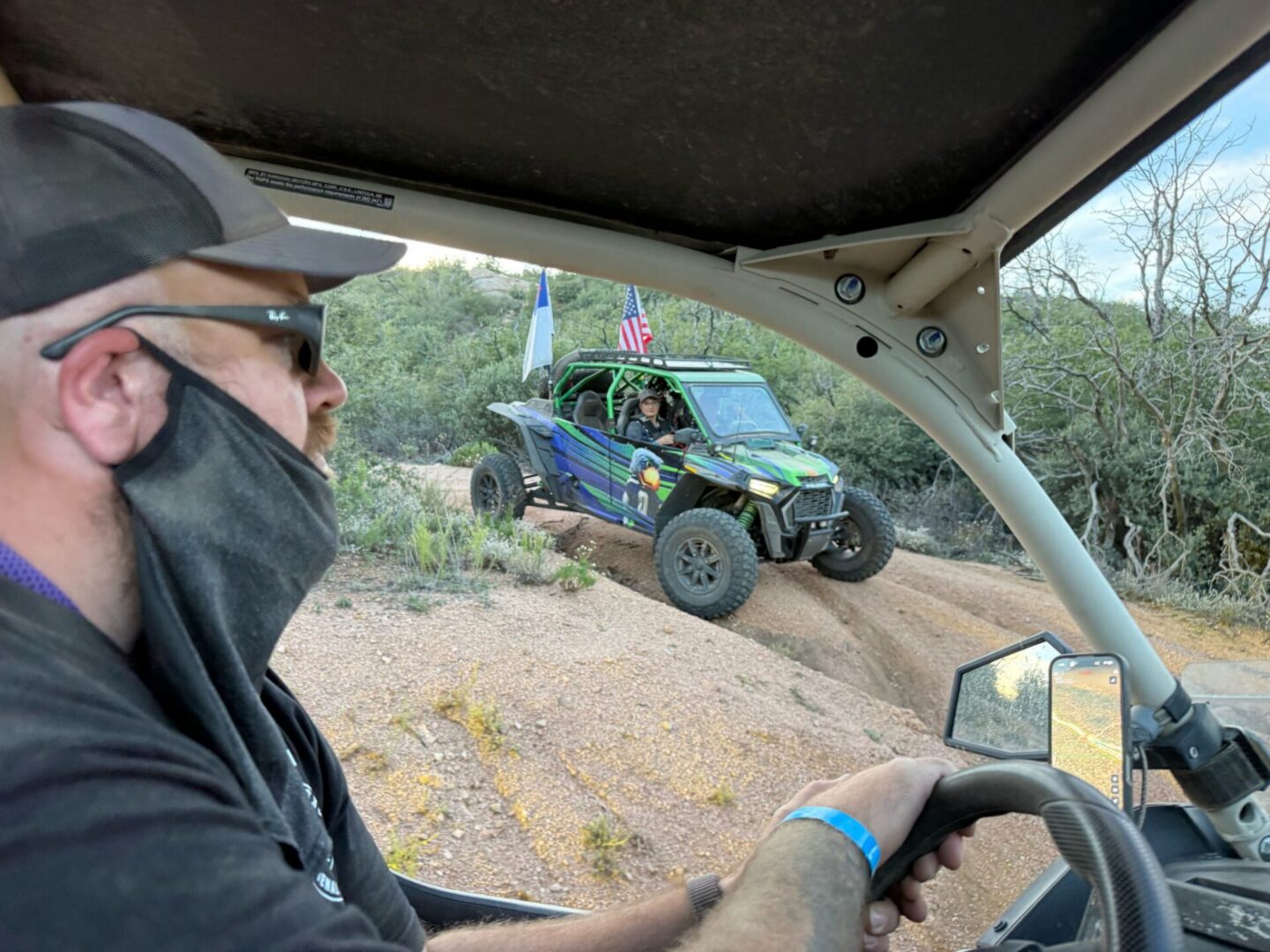 Masked driver viewing off-road UTV on rocky trail