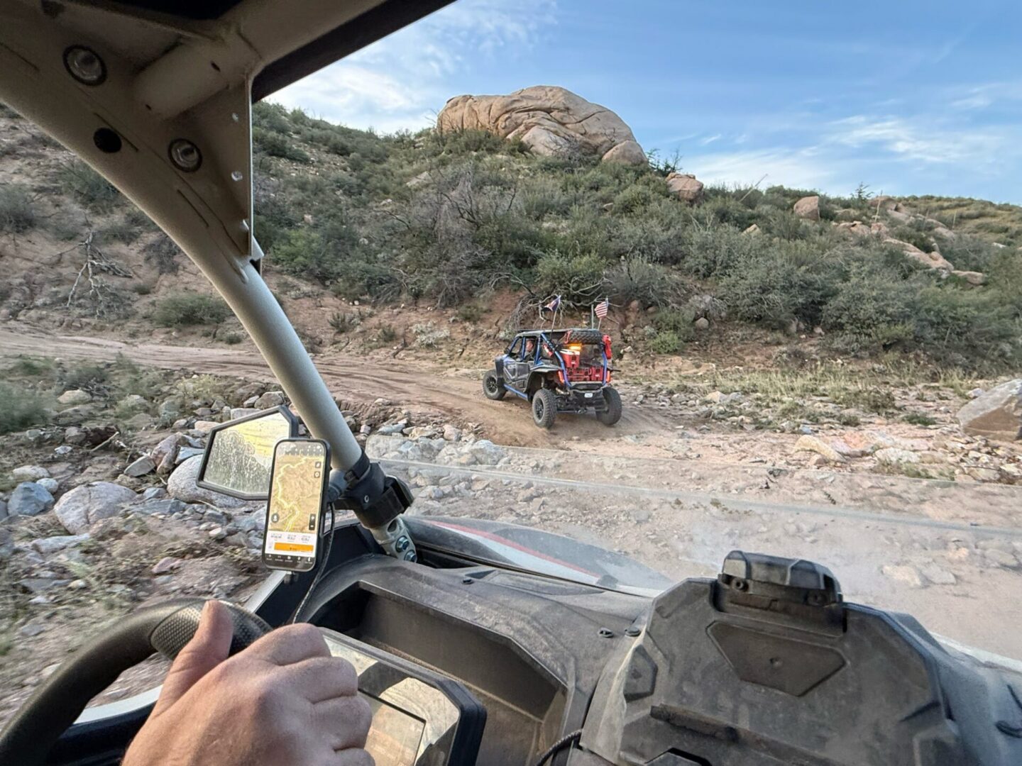 Inside UTV following another on rocky trail