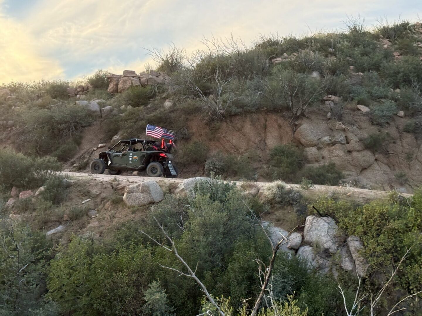 Off-road vehicle with American flag on desert trail