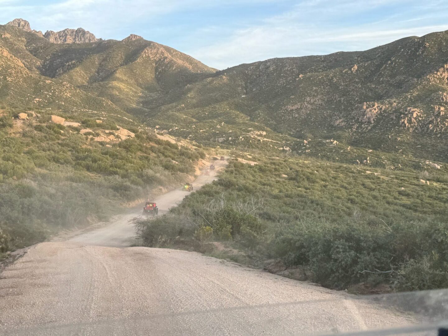 Off-road vehicle kicking up dust on dirt road