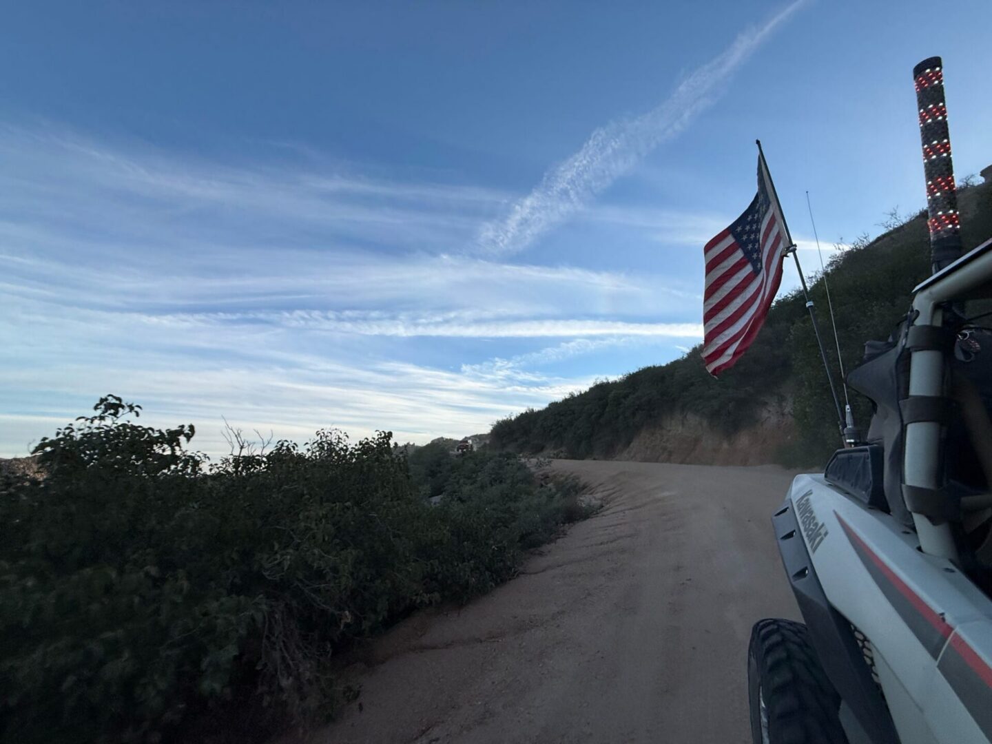 Off-road vehicle with American flag on dirt road