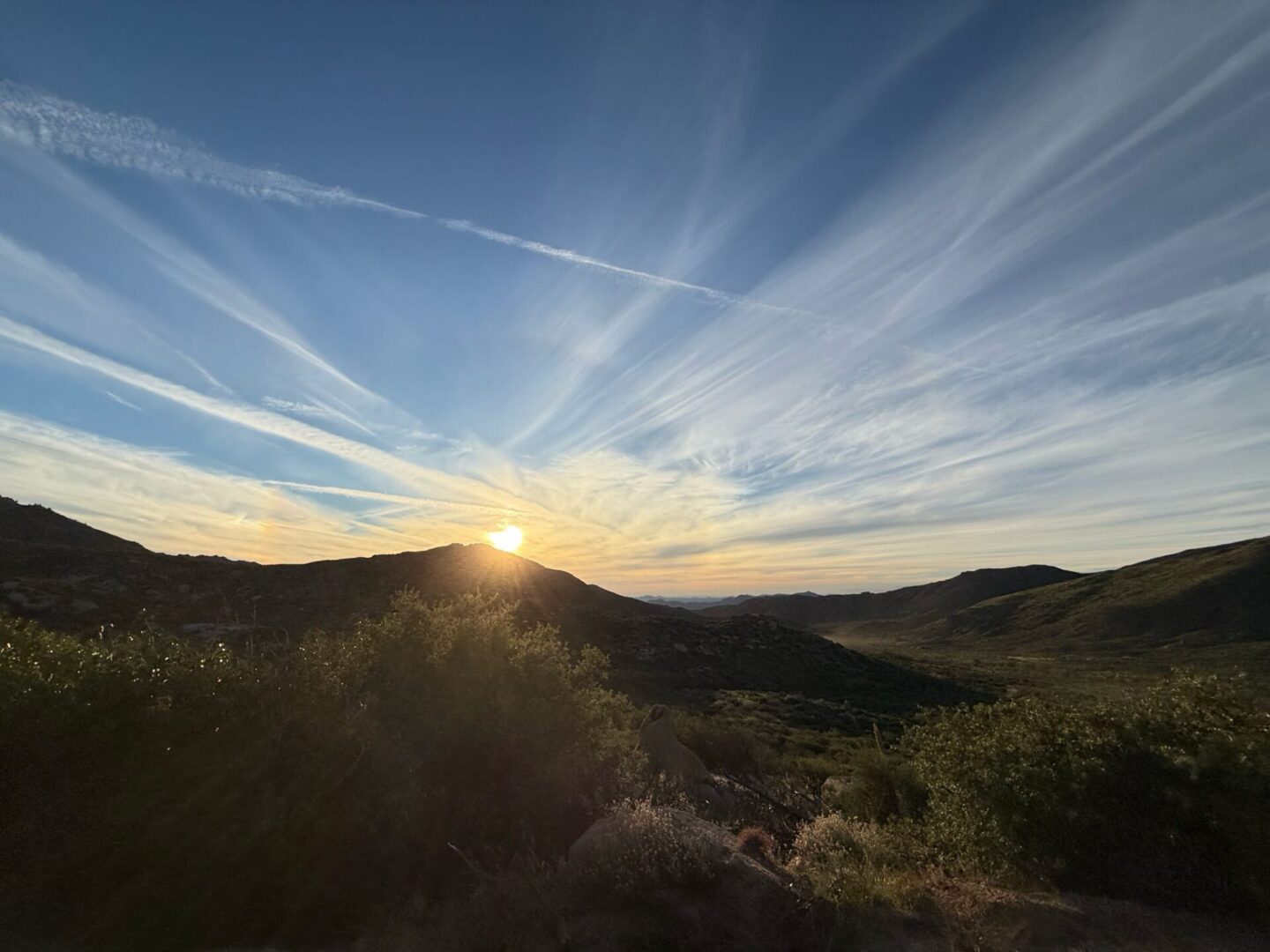 Sunset over hills with streaked sky