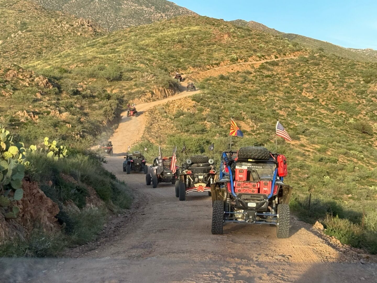 Off-road vehicles with flags on desert trail