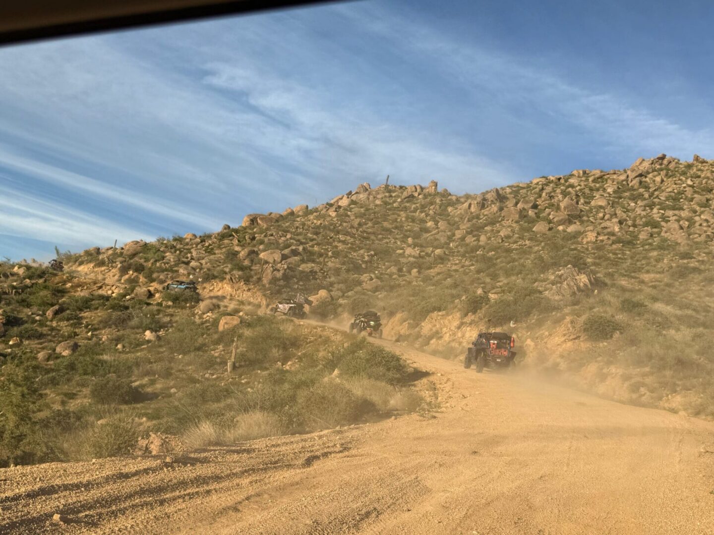 Off-road vehicles kicking up dust on trail