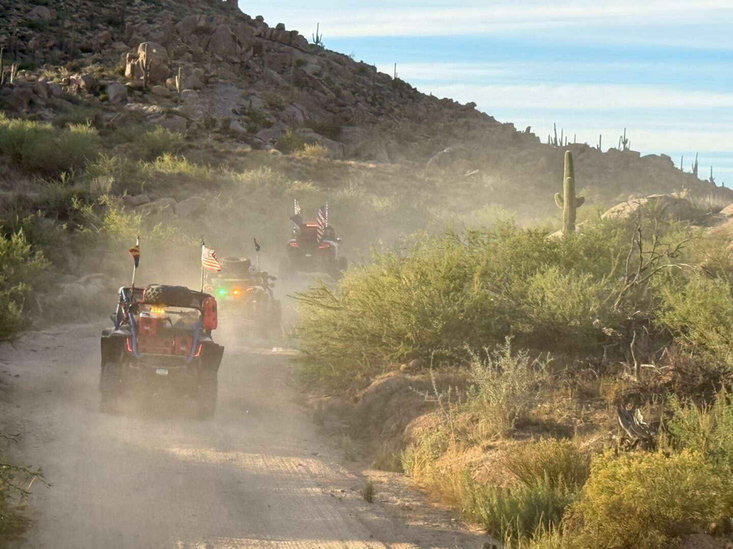 Dune buggies kicking up dust on desert trail