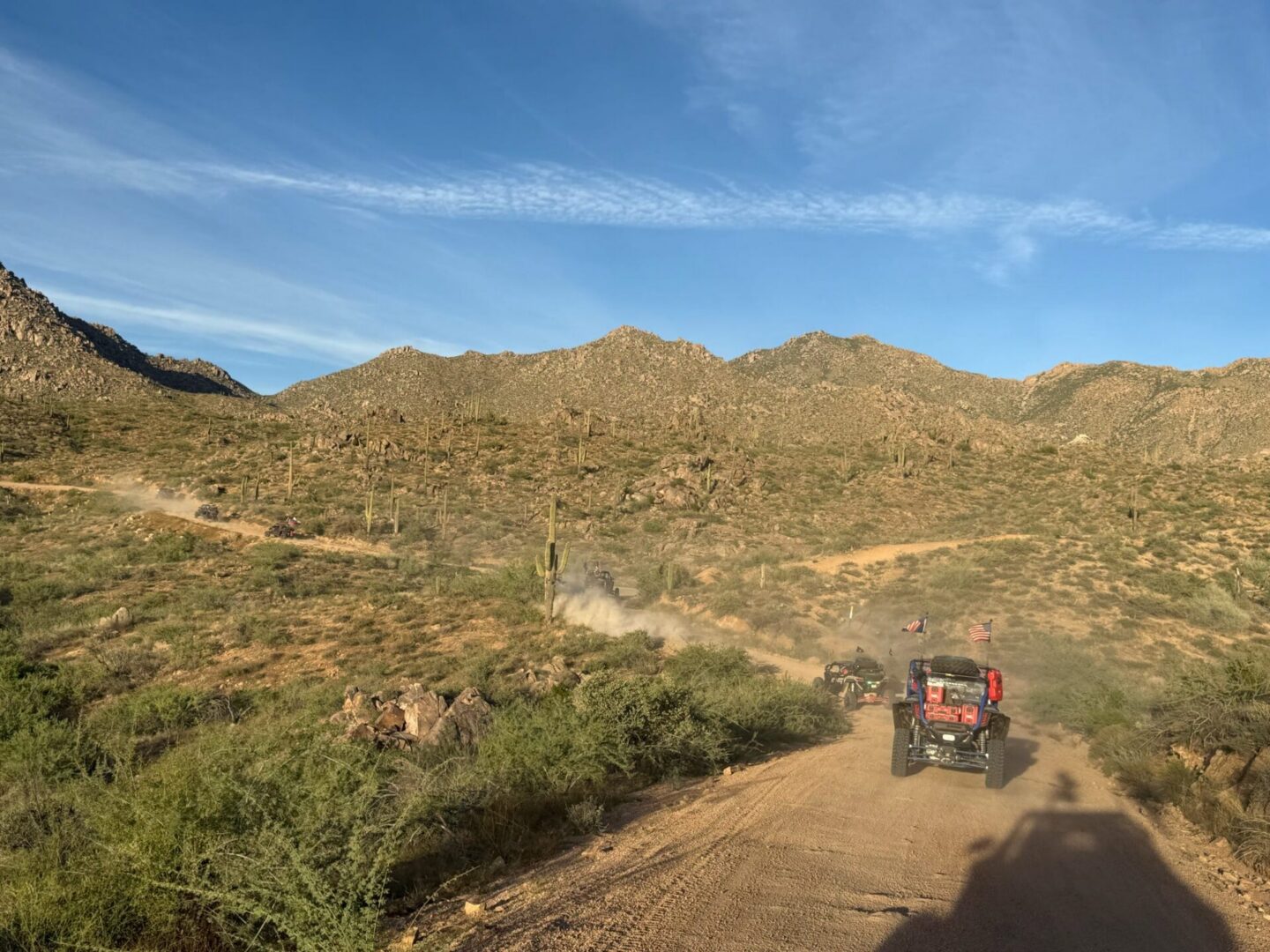 UTVs on desert trail with mountains