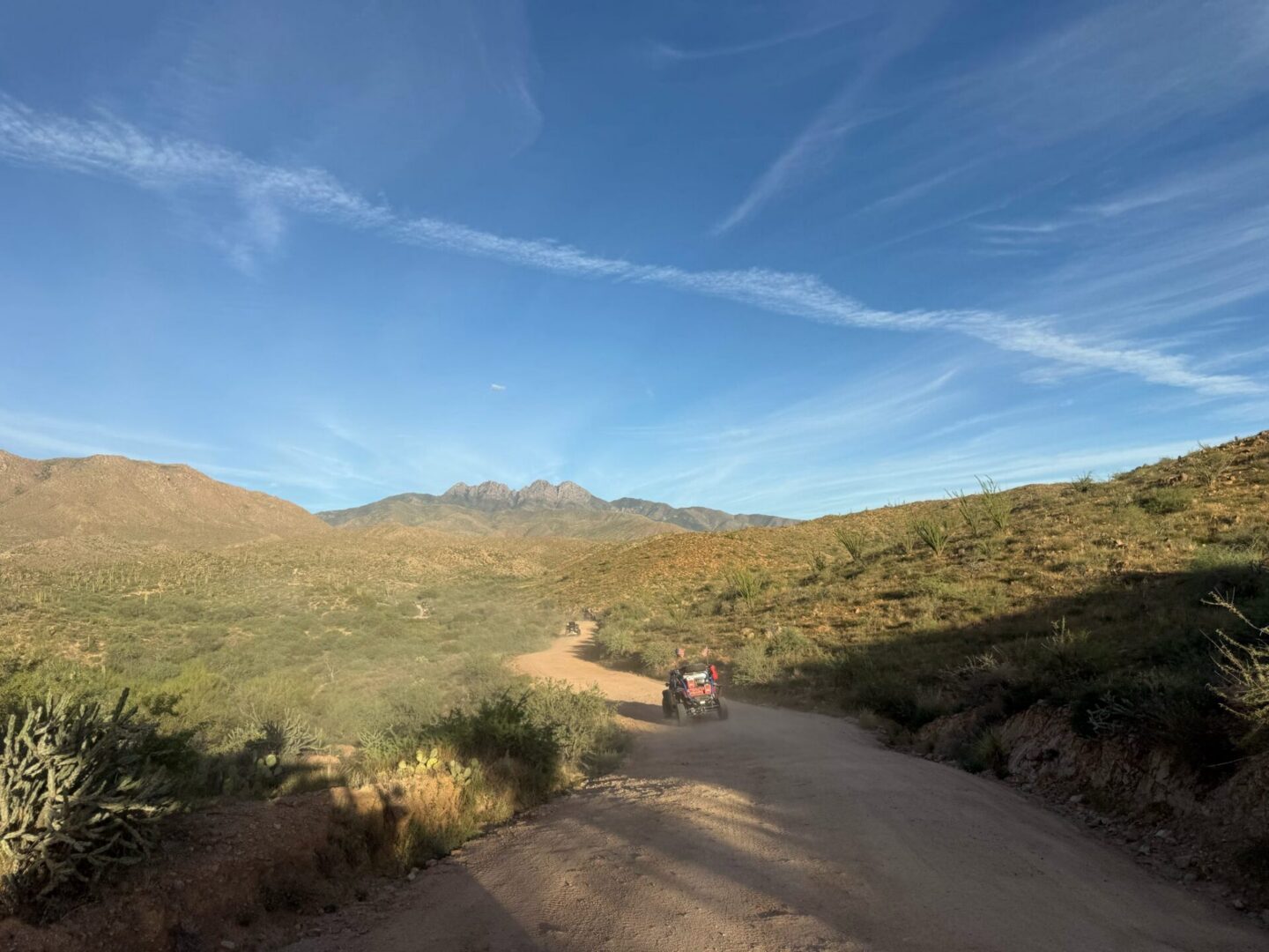 ATV on dirt road in desert landscape