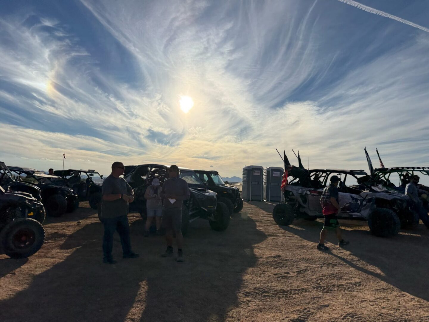 People and off-road UTVs under dramatic sky