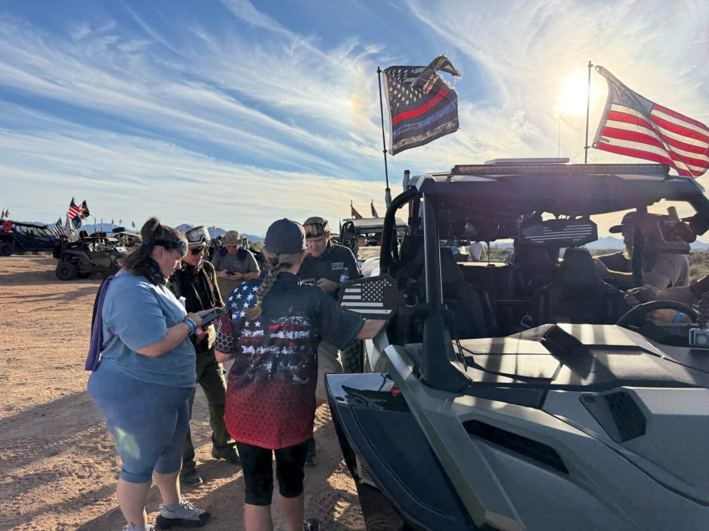 Group near UTV with American flags