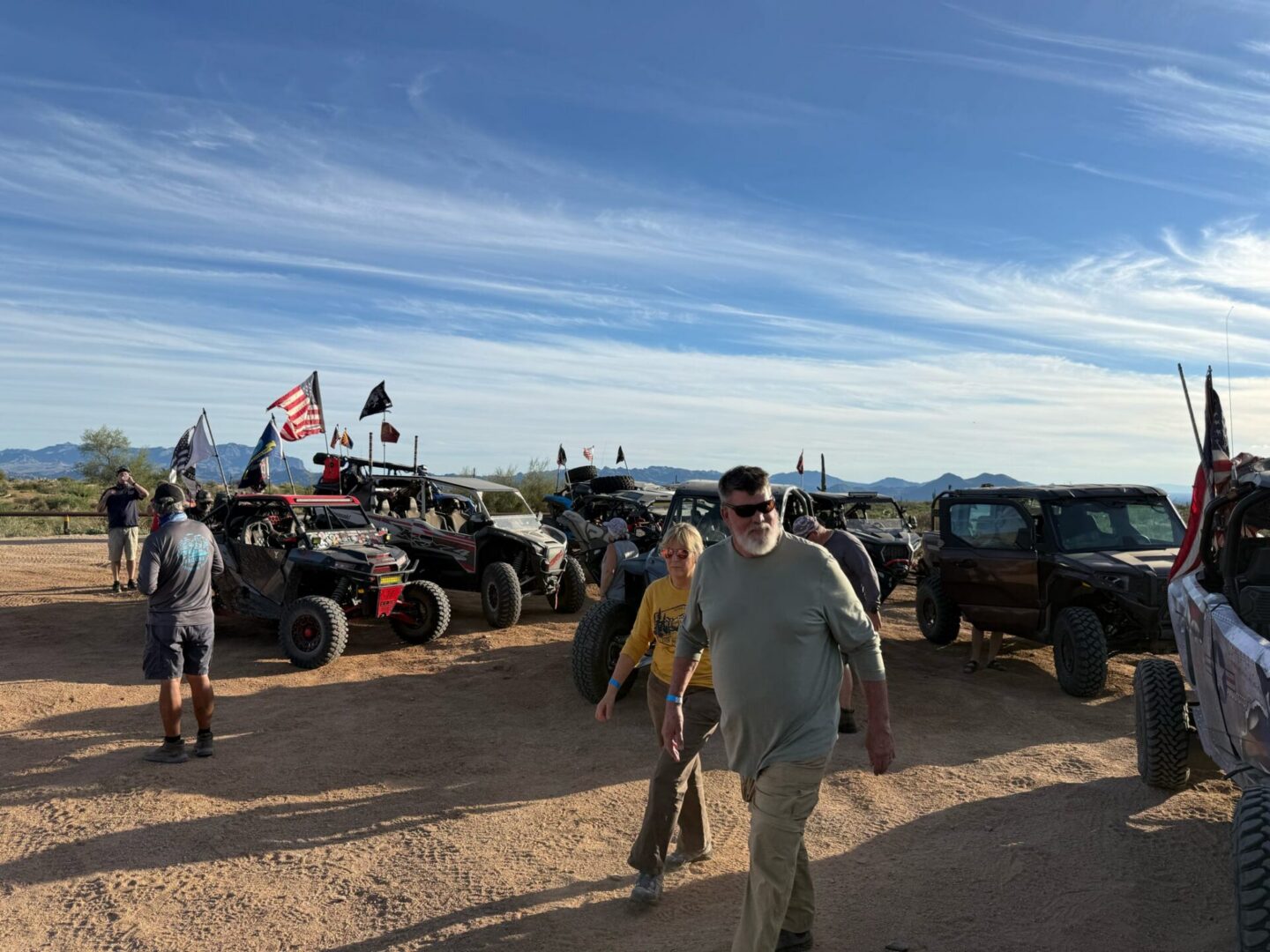 Off-road vehicles and people at desert meetup
