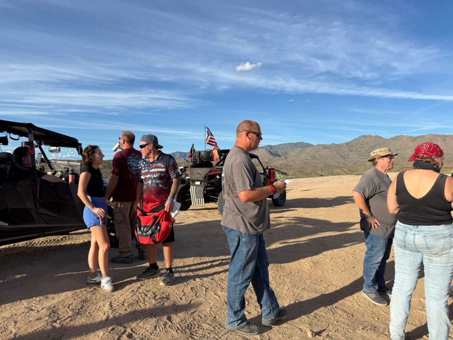 People gathered by off-road vehicles in desert