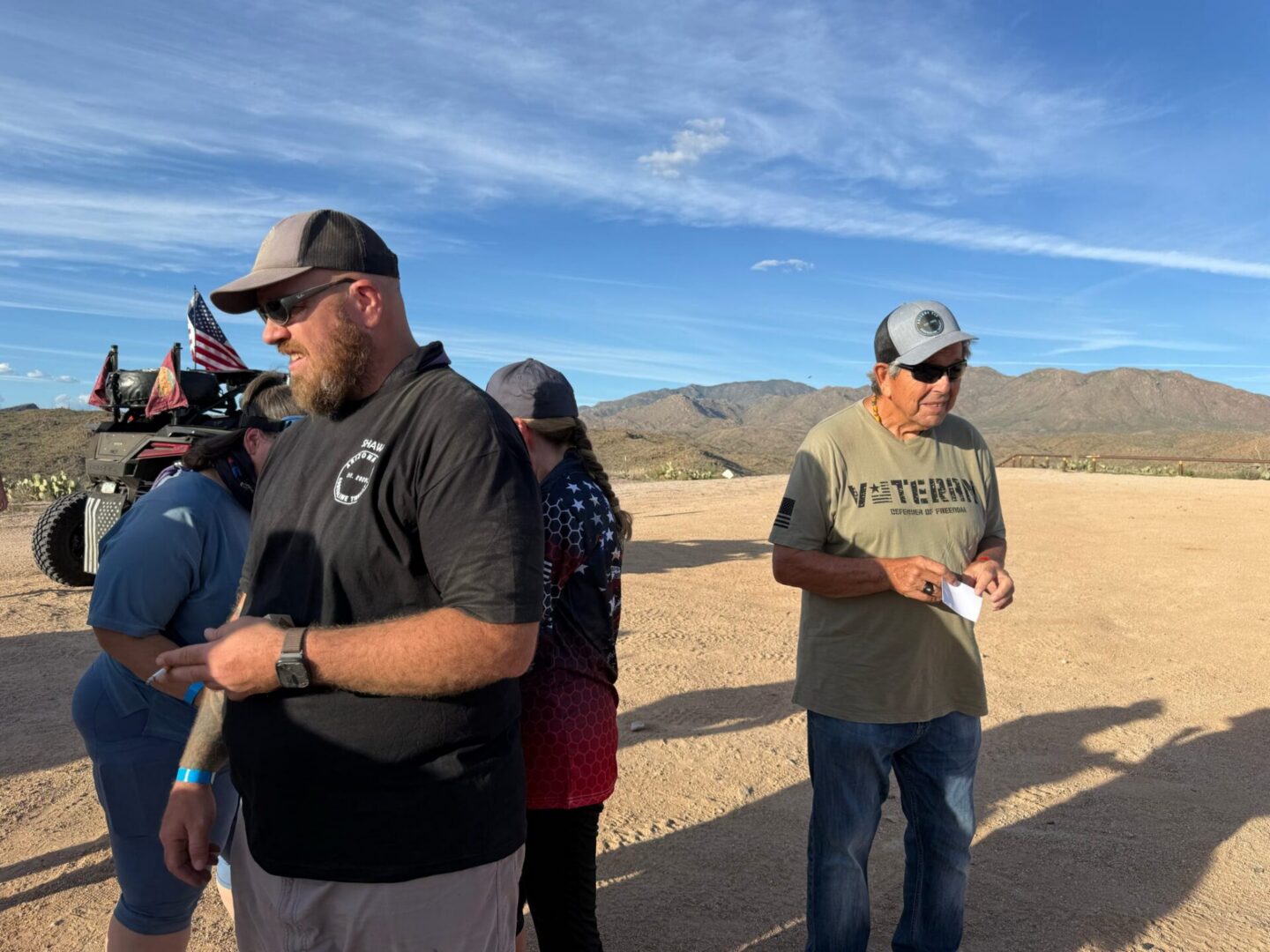 Group of men standing in desert with ATV