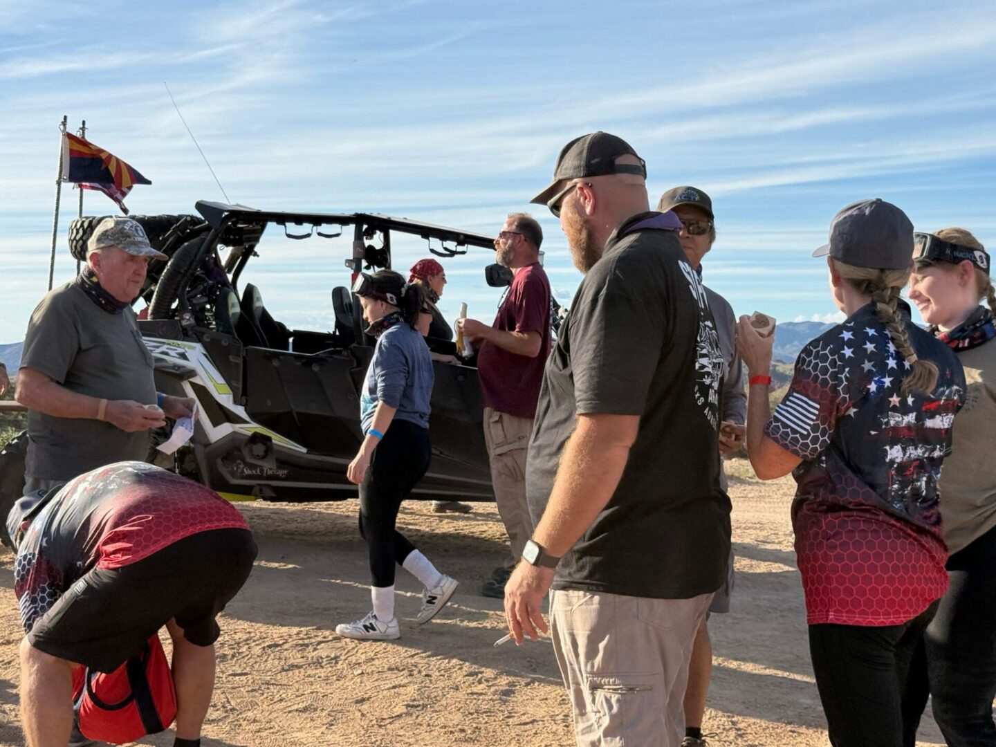 Group of people by off-road vehicle in desert