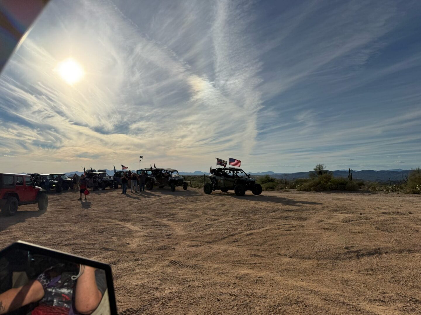 Off-road vehicles gathered in desert under sun
