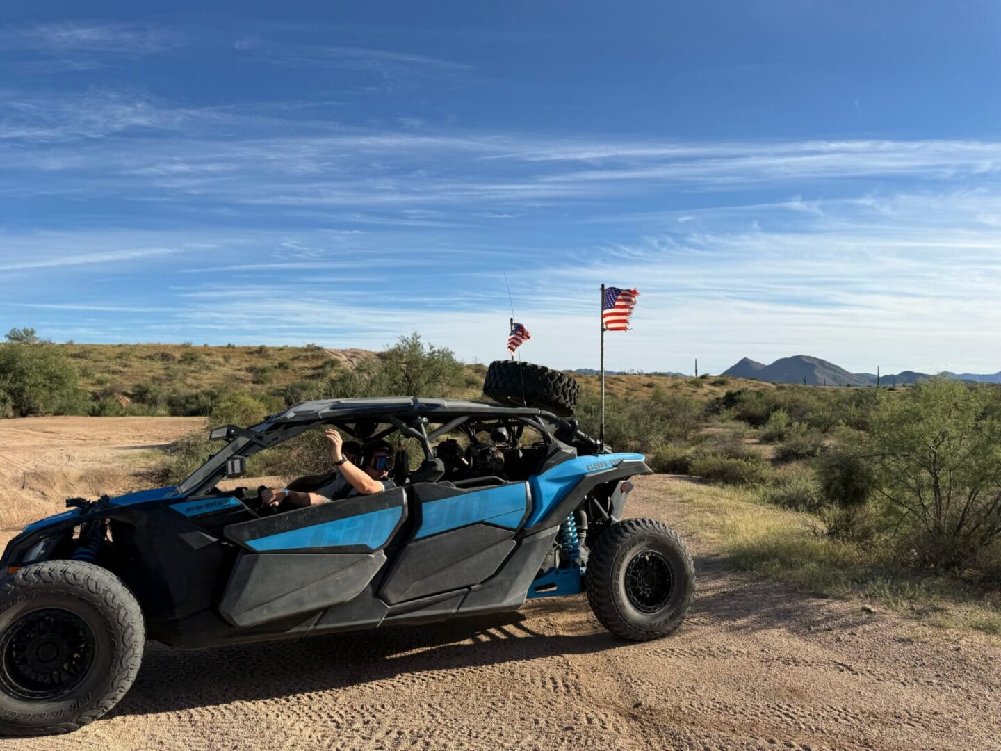 Blue UTV with American flags in desert