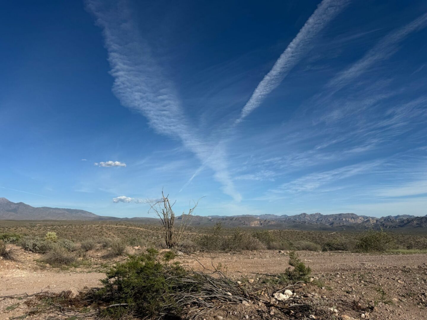 Desert landscape with mountains and contrails