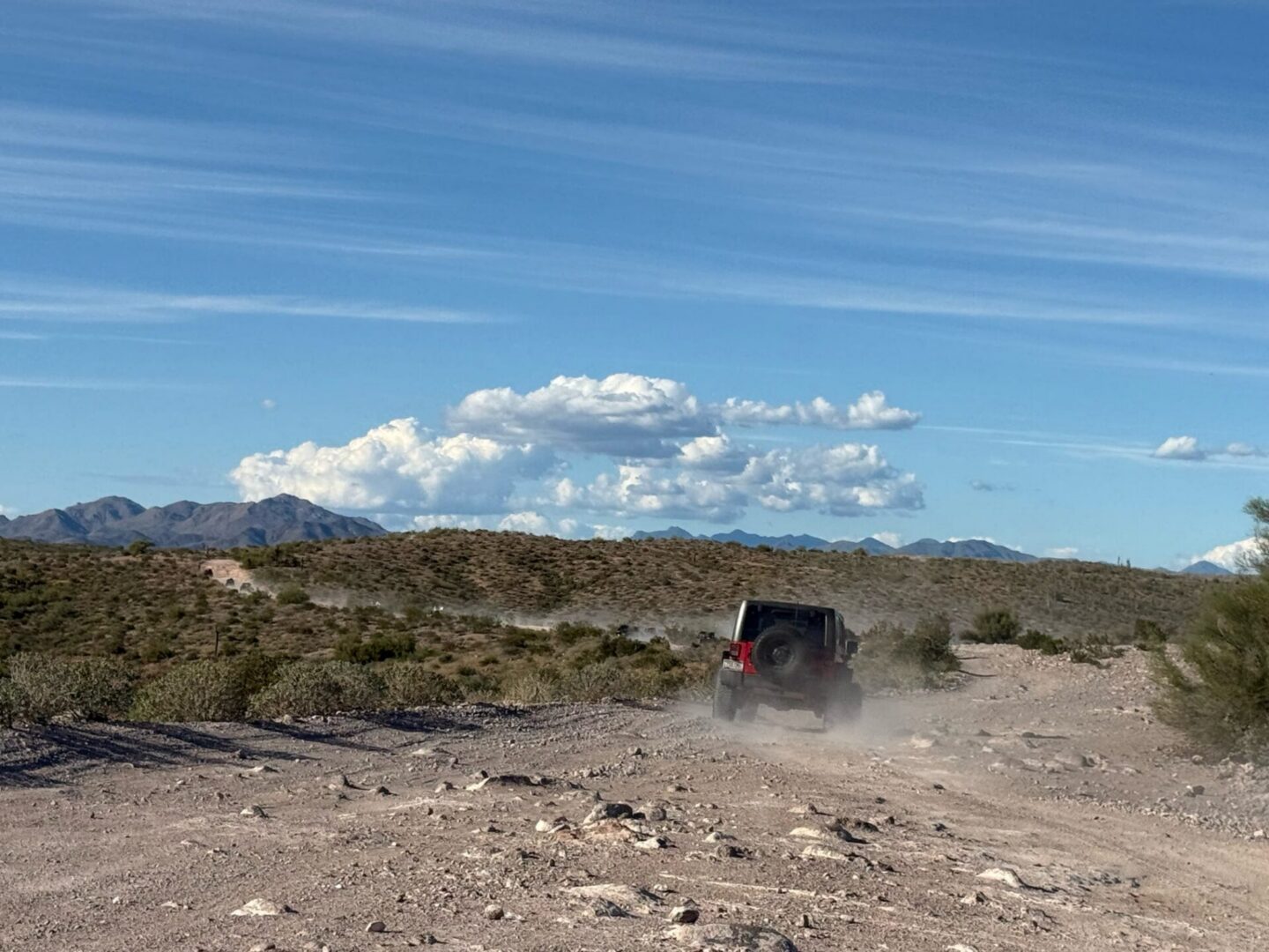 Off-road vehicle kicking up dust on trail