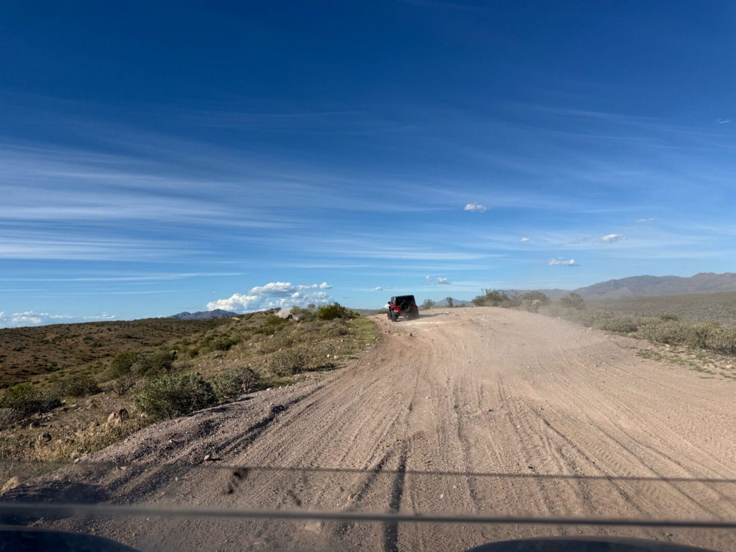 SUV driving on remote dirt desert road