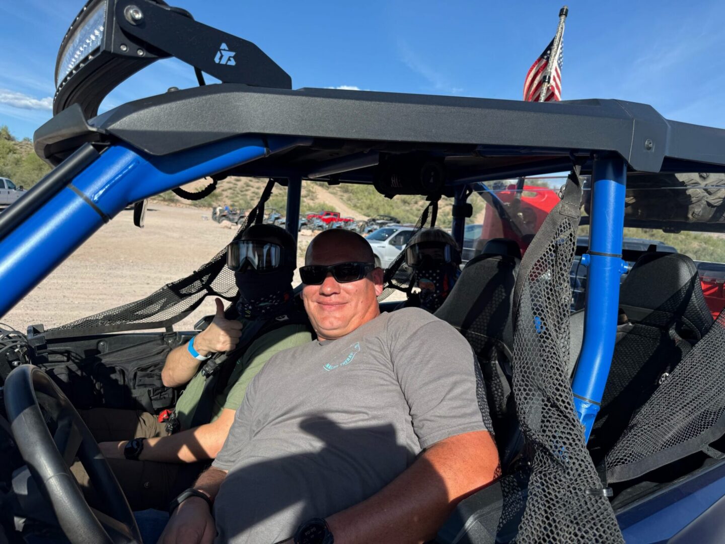Off-road UTV with smiling occupants and flag