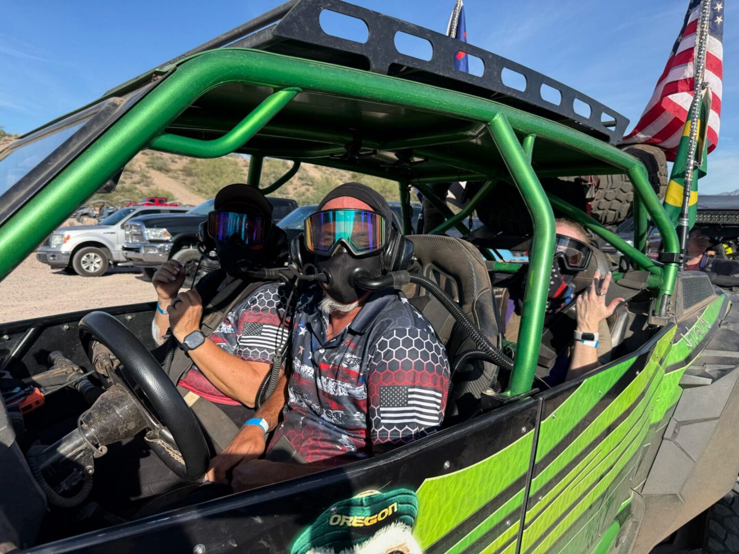 Three masked riders in green off-road vehicle