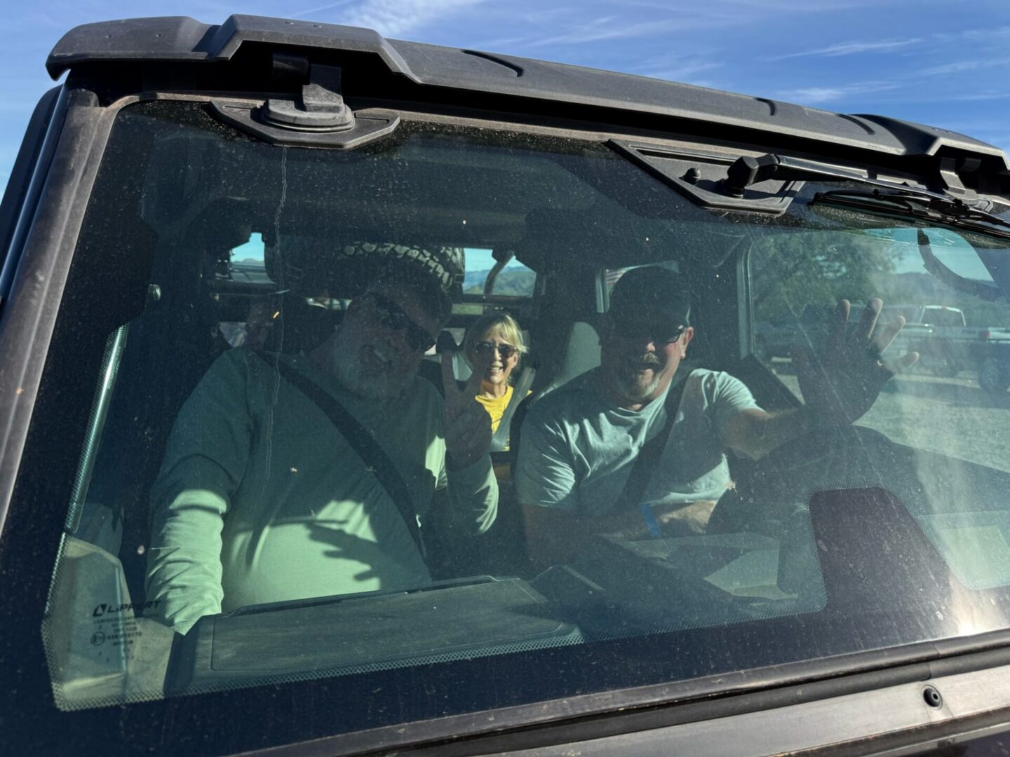 Three passengers visible through vehicle windshield