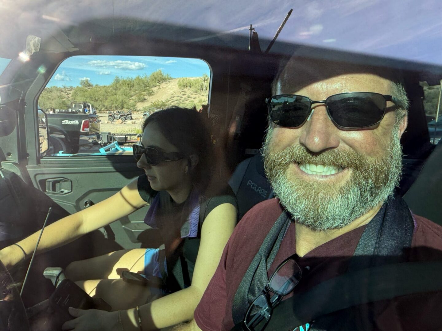 Smiling bearded man and woman in car