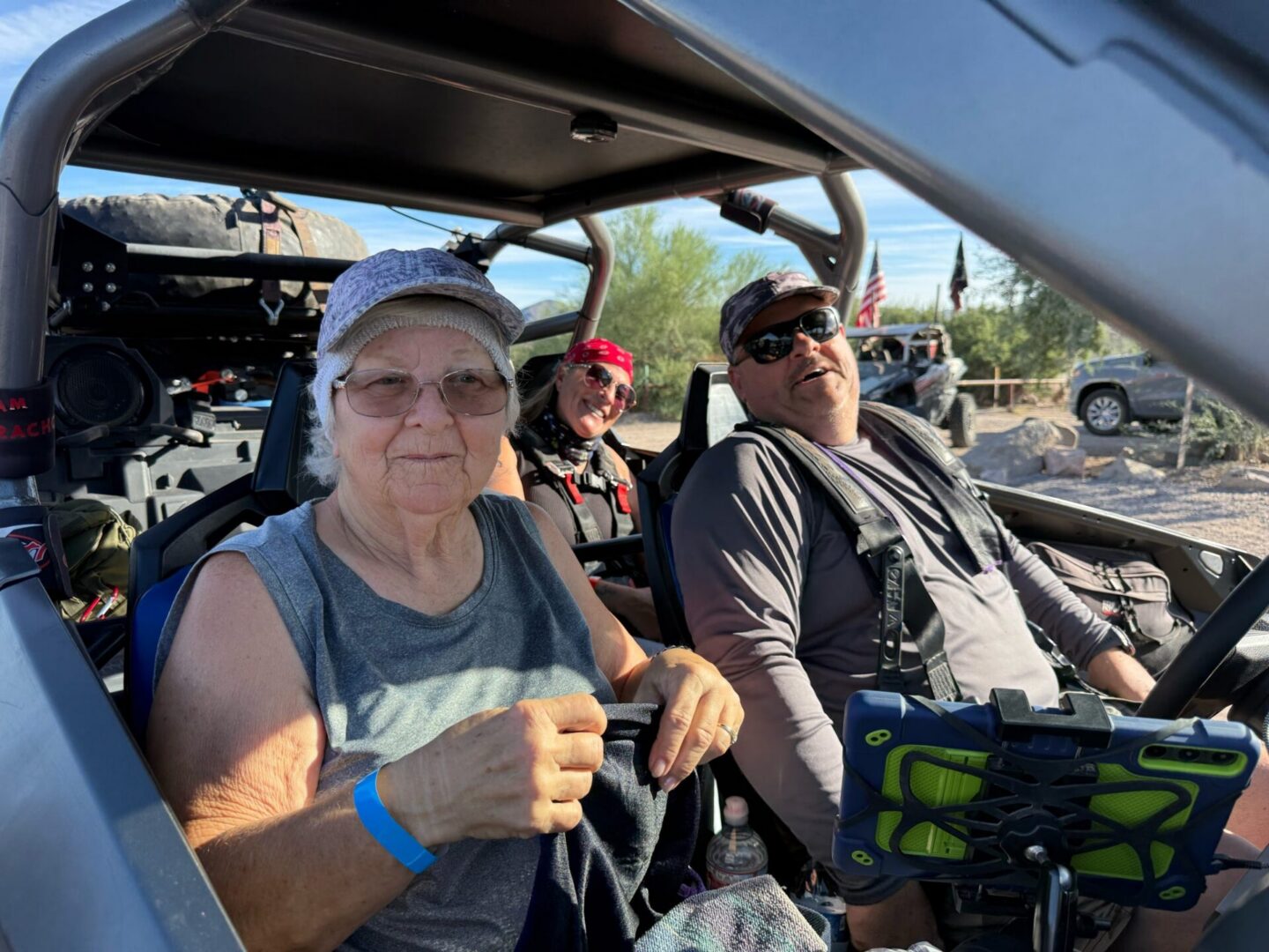 Three people smiling in off-road vehicle