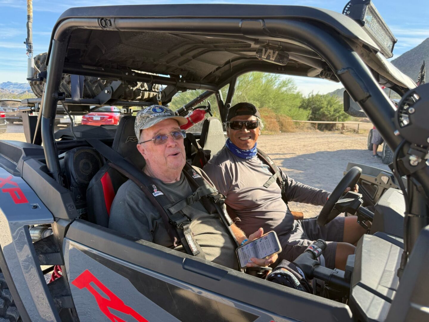 Two men smiling in off-road utility vehicle