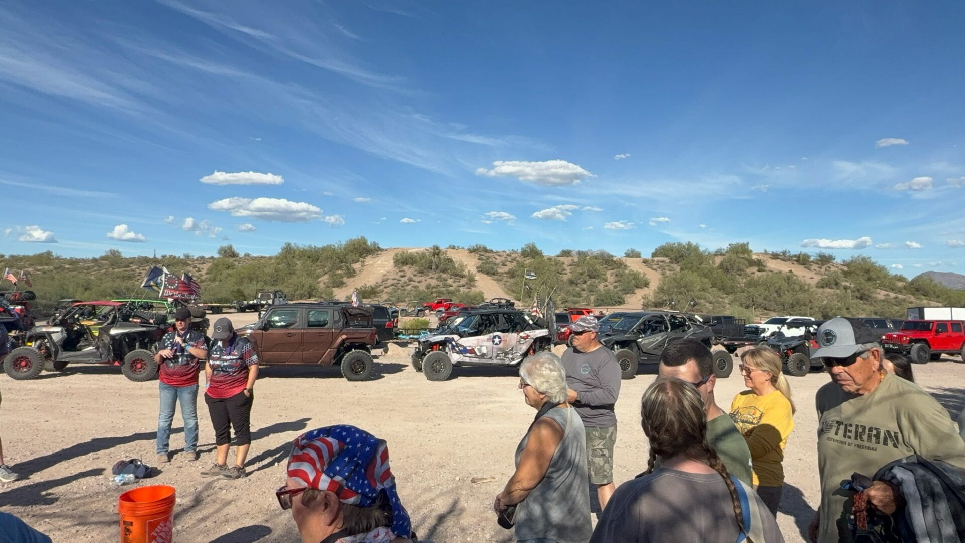 People gathered beside off-road vehicles in desert
