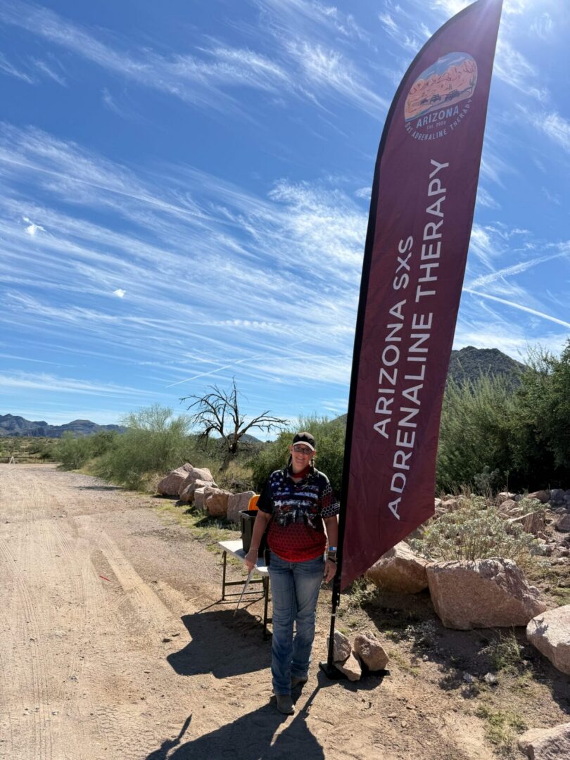 Person beside Arizona SXS therapy flag in desert