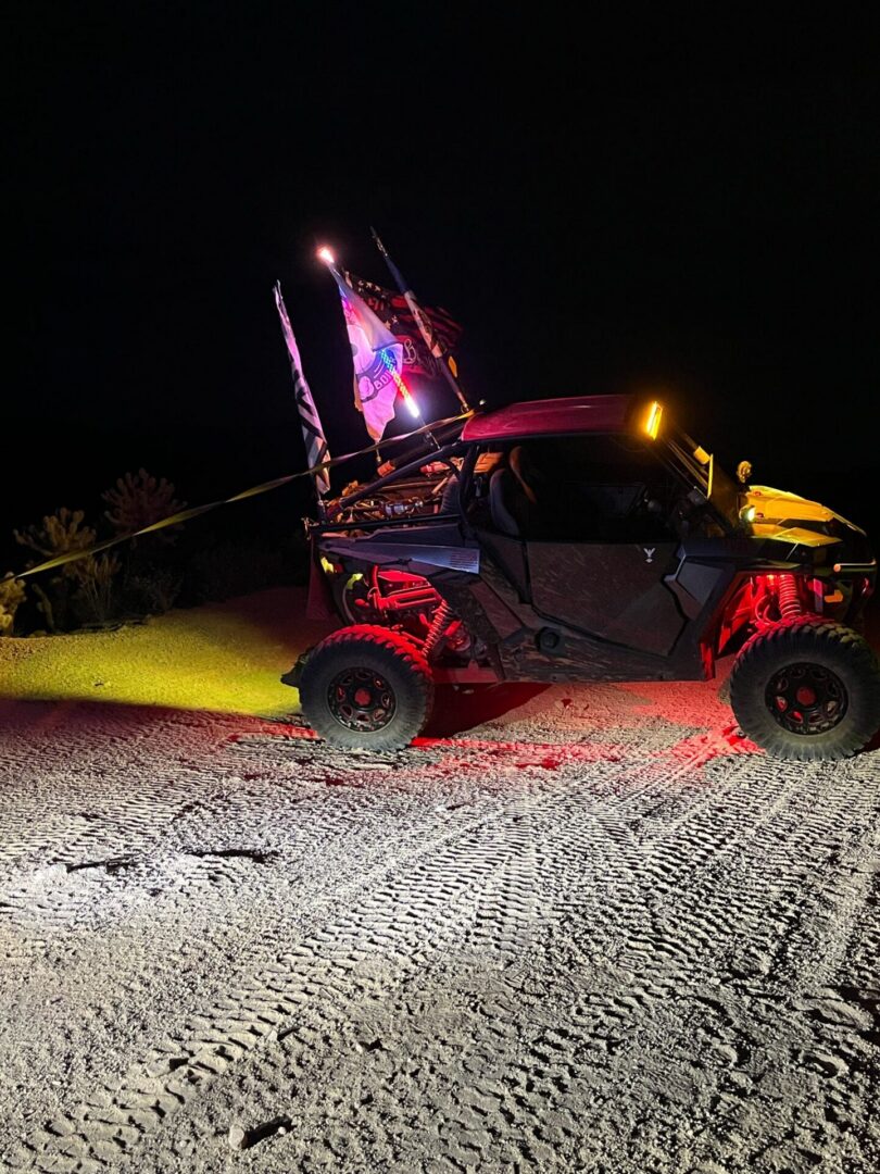 Off-road UTV with flags and red lights