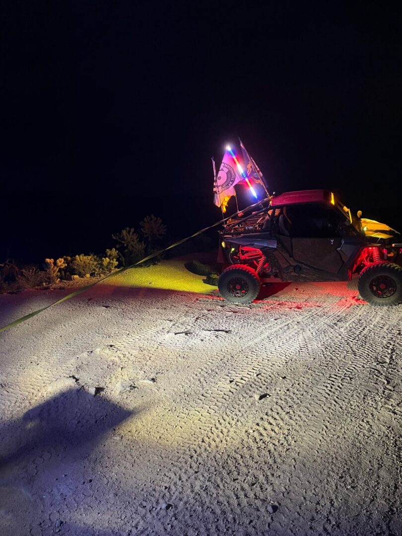 Off-road UTV with illuminated flags at night