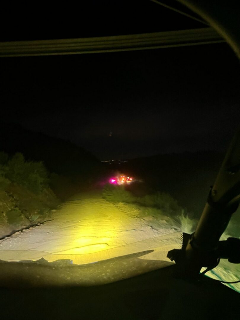 Vehicle headlights illuminating nighttime dirt road