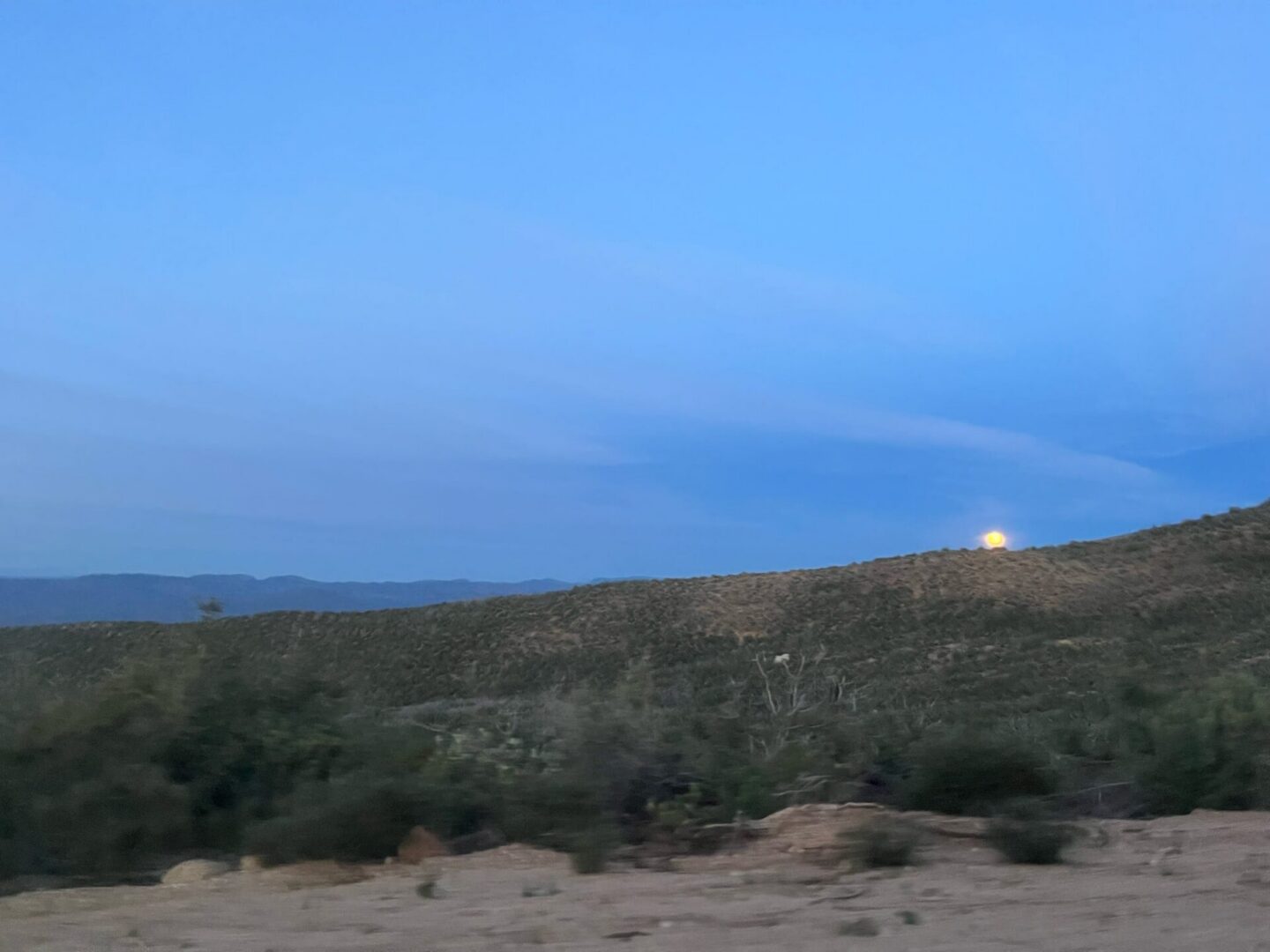 Moon over desert hills at dusk