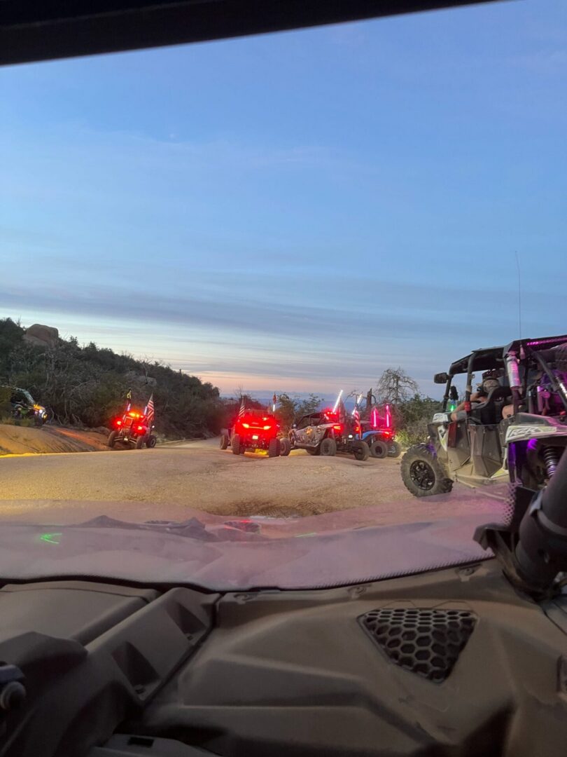 View from vehicle: UTV convoy at dusk
