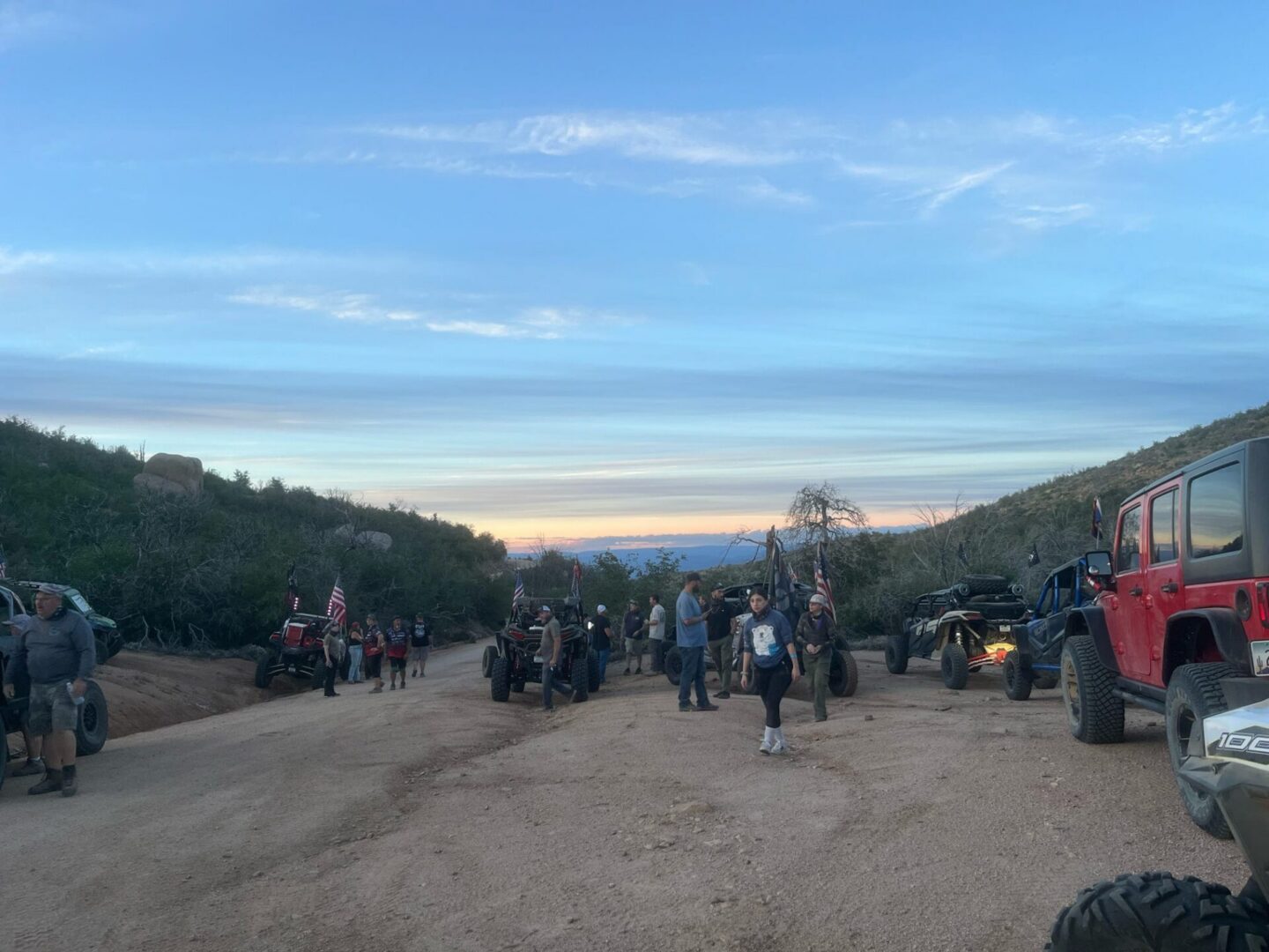 Off-road vehicles and people at sunset