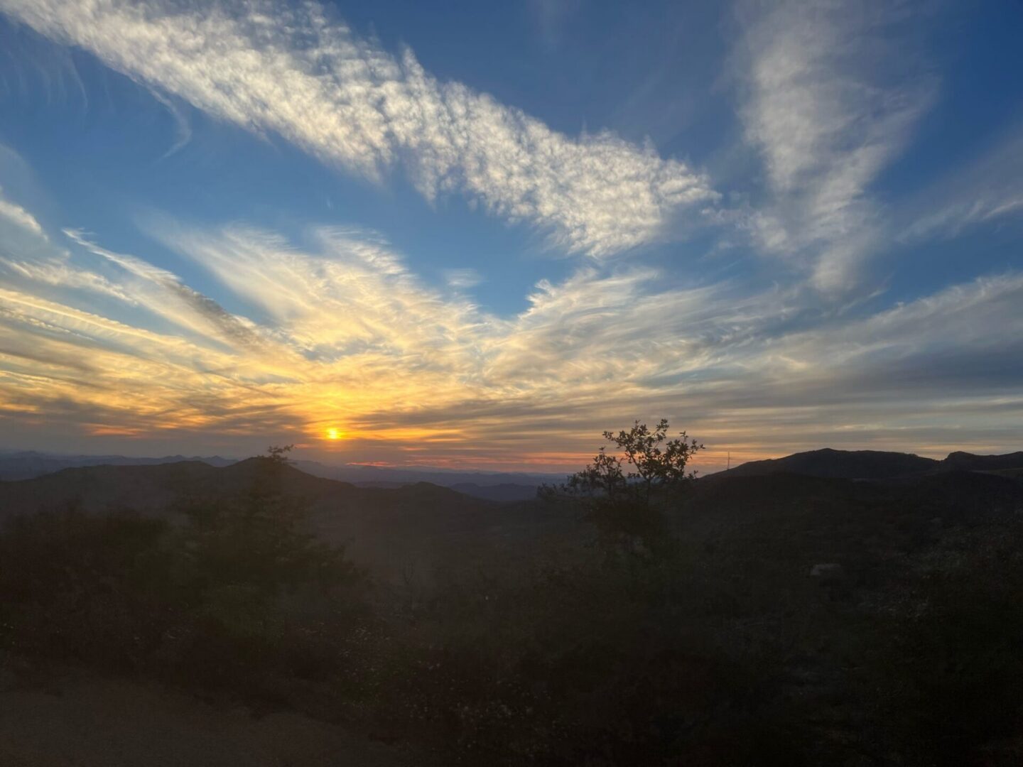 Sunset over mountains with streaked clouds