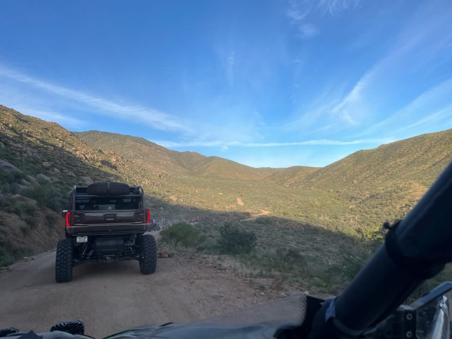 Lifted pickup on dirt road through mountains