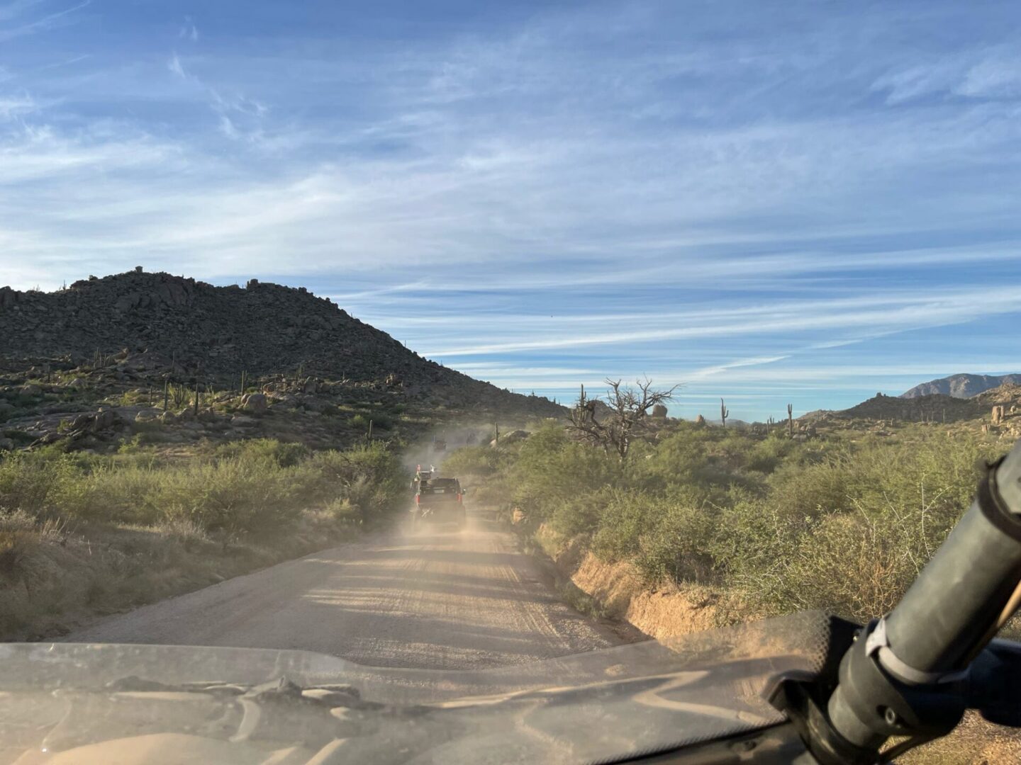 Dashboard view of off-road vehicles on desert trail