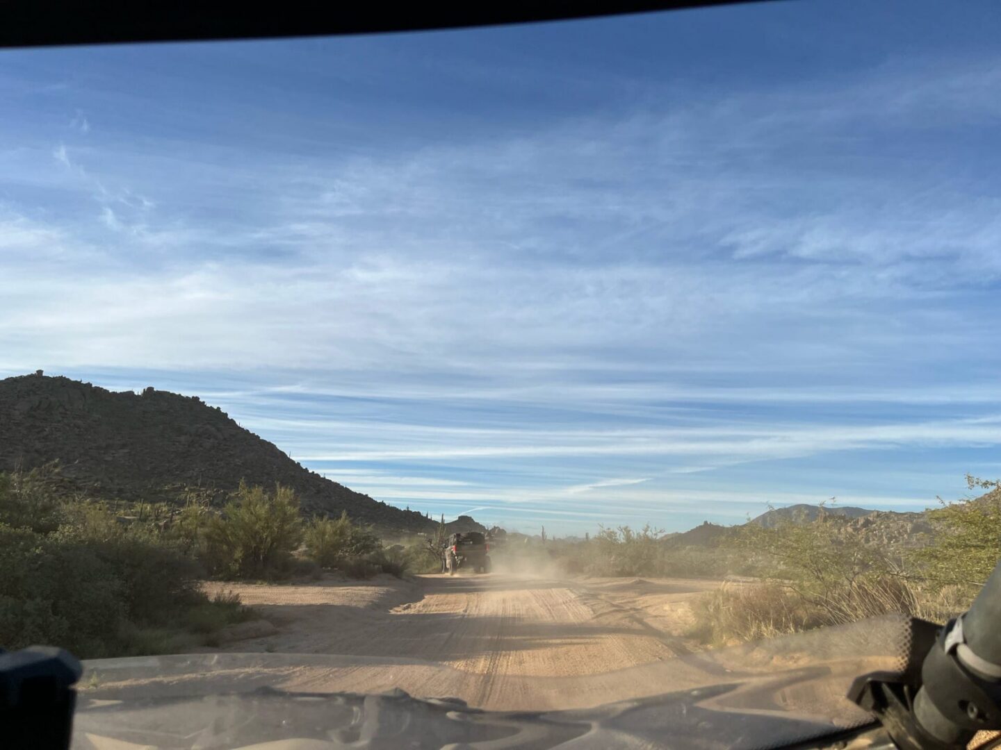 Driver's view of dusty desert road