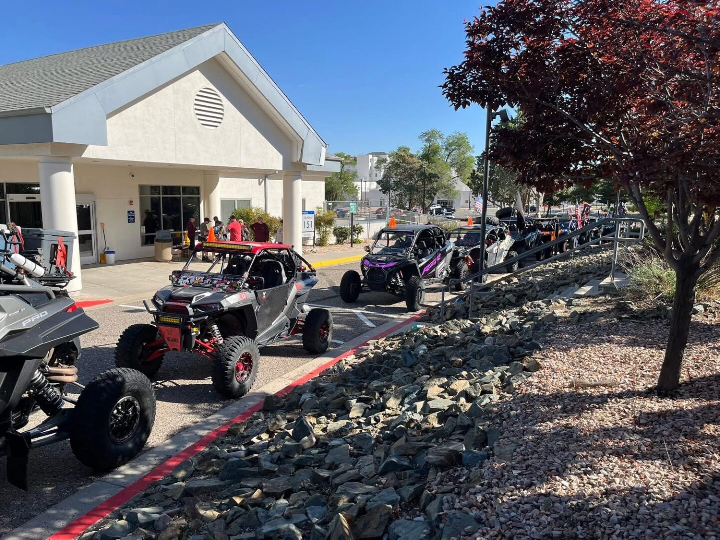 Line of off-road UTVs parked by building