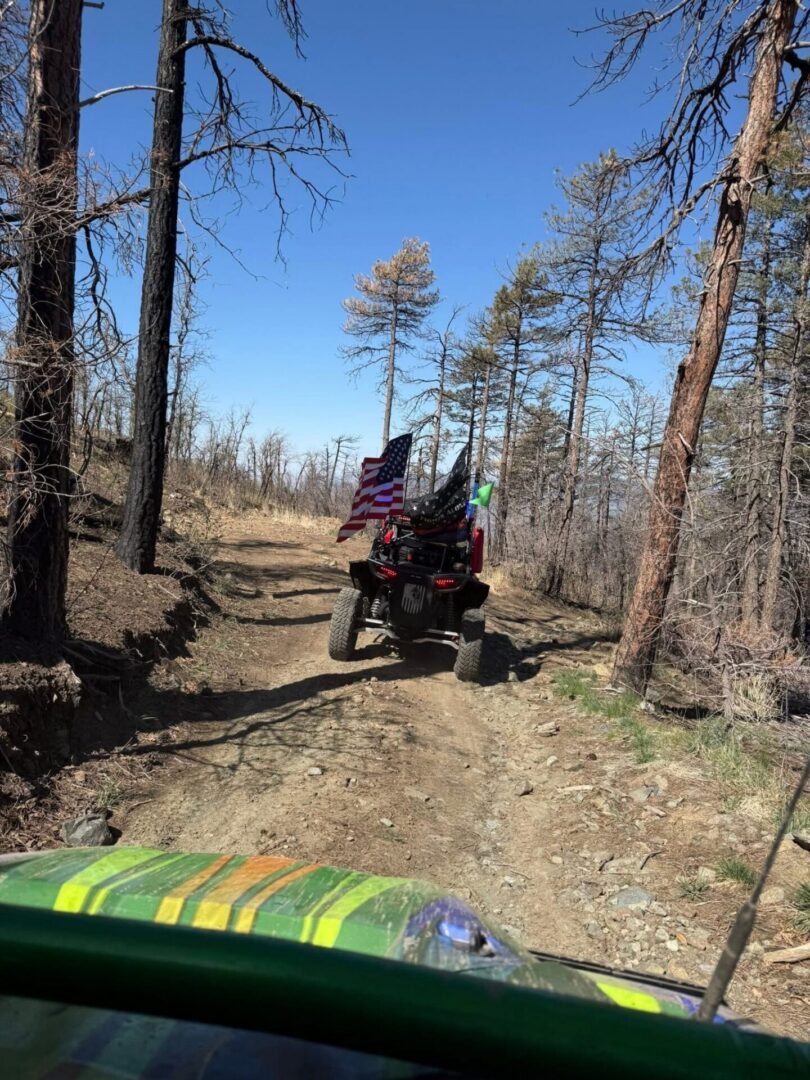 ATV with American flag on dirt trail