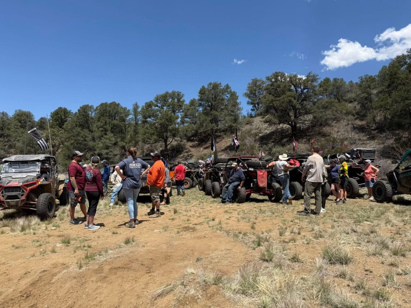 Off-road UTVs and riders in forest clearing
