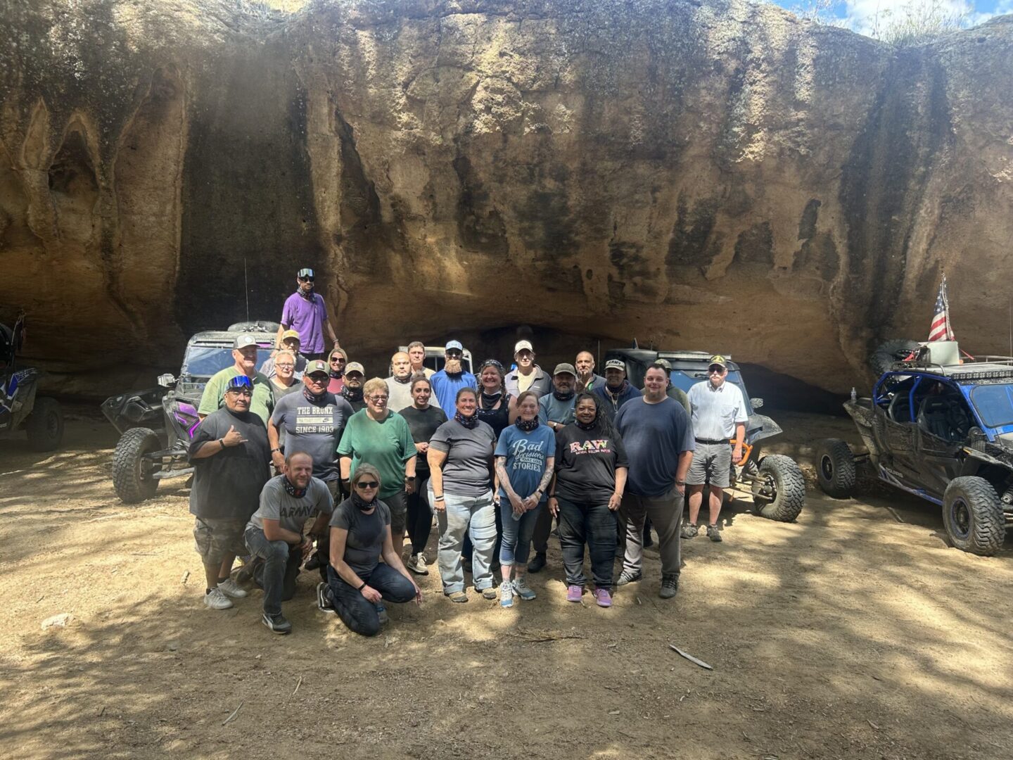 Group of off-roaders posing by rock formation