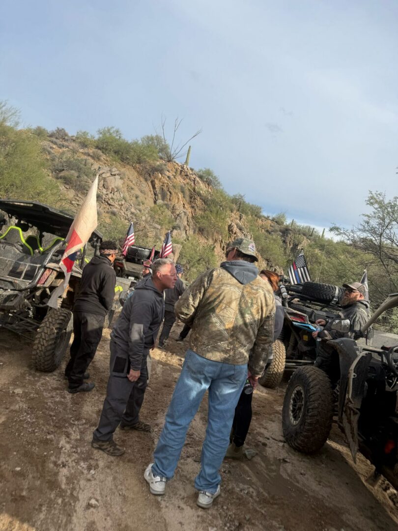 Off-roaders gathered around UTVs in desert