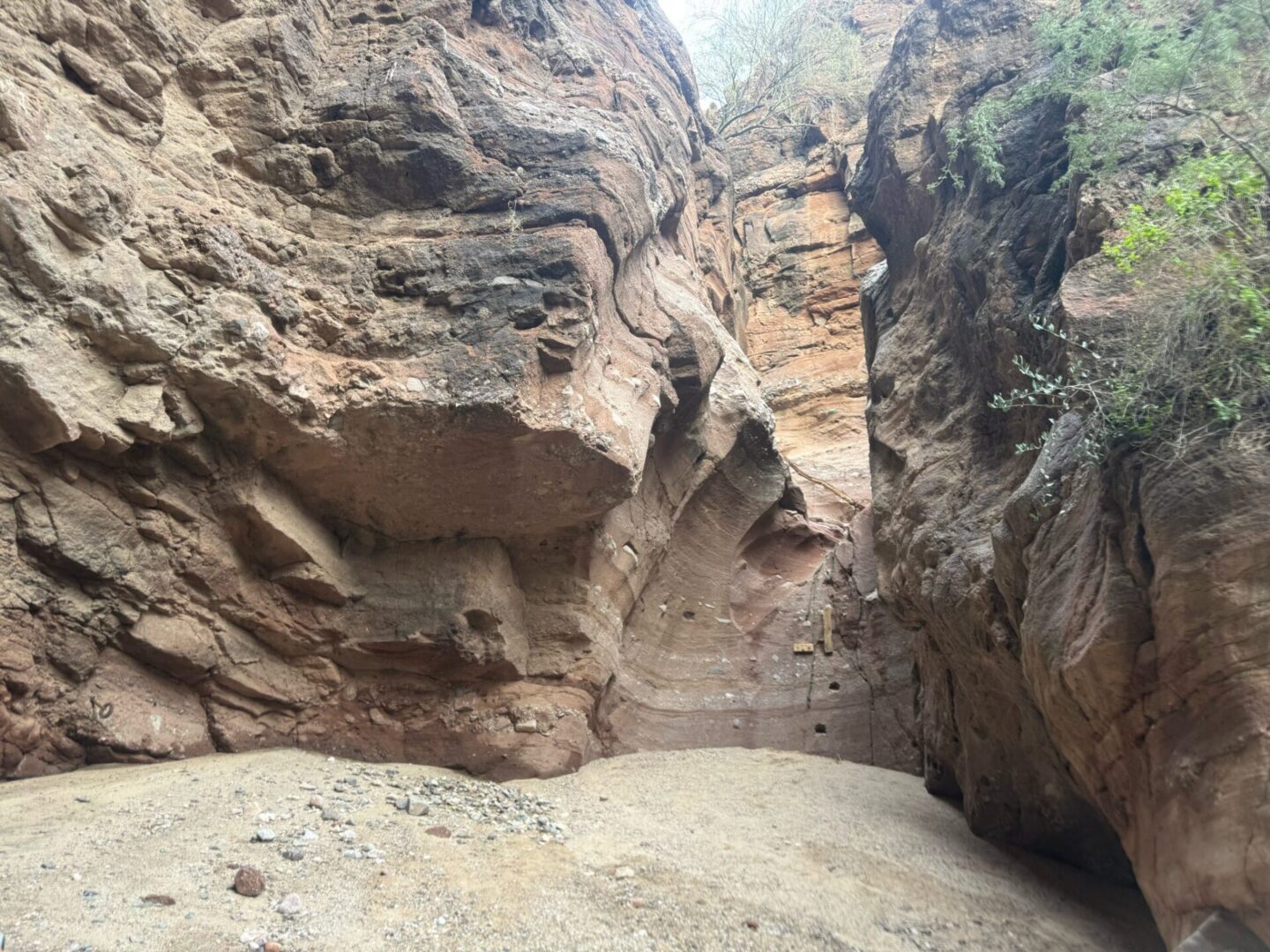 Red sandstone slot canyon with sandy floor